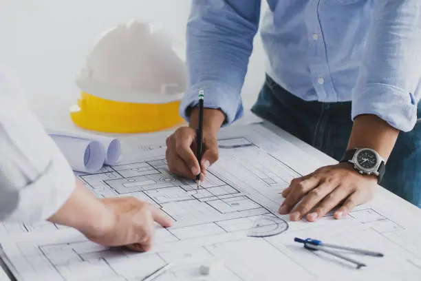 engineer meeting for an architectural project. working with partner and engineering tools working on blueprint architectural project at the construction site at desk in the office.