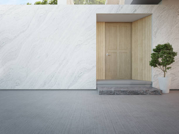 maison de luxe avec mur en marbre et porte d’entrée en bois dans un design moderne. - marble building photos et images de collection