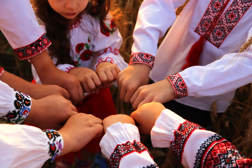 Las manos de los niños en camisas bordadas se unen en un gesto de bienvenida. Las manos unidas forman un cykle simbolizan la unidad. Día de la Independencia de Ucrania, Constitución, Bordado photo