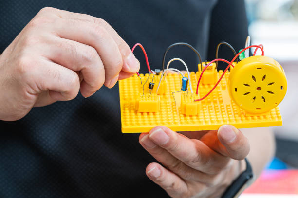 Student's hand holding an invention kit and connecting electric wires. Student's hand holding an invention kit and connecting electric wires. memory technics and game stock pictures, royalty-free photos & images