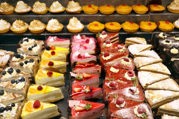 istock Different cakes with fresh fruits and berries in store window 1330175622