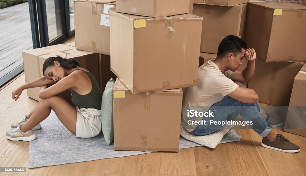 Shot of a young couple ignoring one another at home Can't see eye to eye when we're both blind Divorce Stock Photo