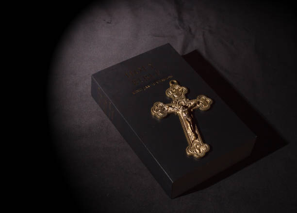 istock bronze cross and bible on table 1330190681
