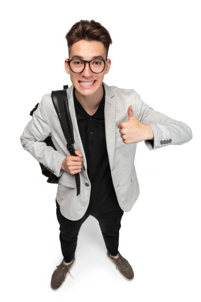 istock Vertical image of young caucasian guy, student in grey jacket with backpack isolated over white studio background. 1330196922