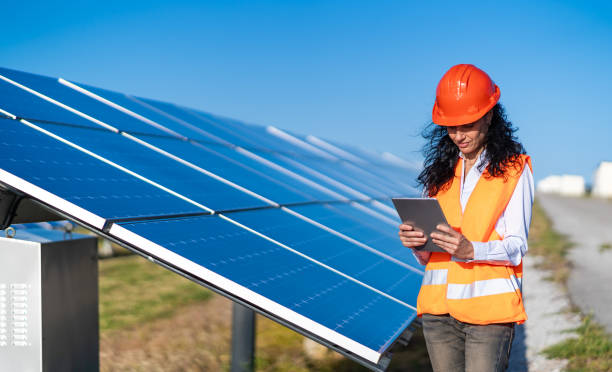 istock Operation and maintenance in solar power plant ; female engineer, holding notepad, working on checking the solar panels   for innovation of green energy for life 1330198569