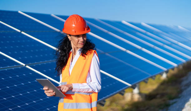 istock Operation and maintenance in solar power plant ; female engineer, holding notepad, working on checking the solar panels   for innovation of green energy for life 1330198577