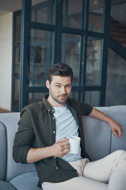 istock Handsome young man holding cup with drink 1330201179