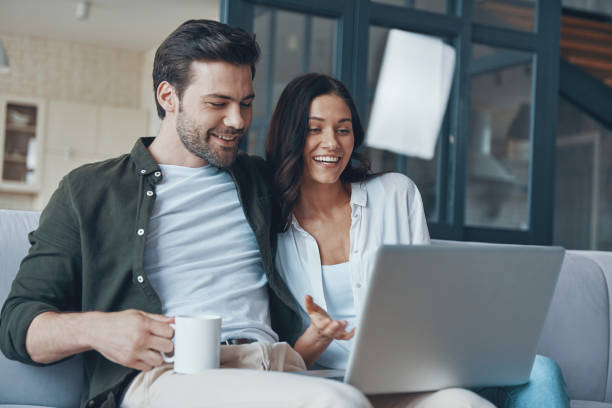 istock Beautiful young couple drinking coffee and looking on the laptop 1330201248