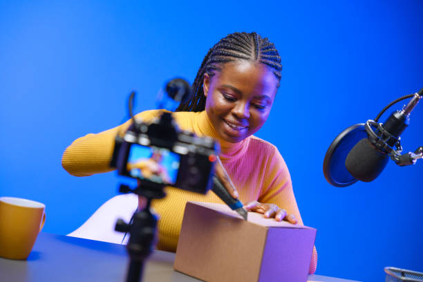 istock A dark-skinned vlogger girl opens a cardboard box in her studio with a stationery knife. 1330205592