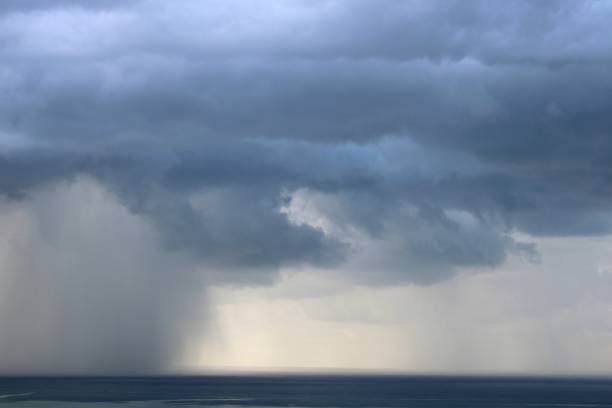 istock Dark storm clouds and heavy rain over the sea 1330205692