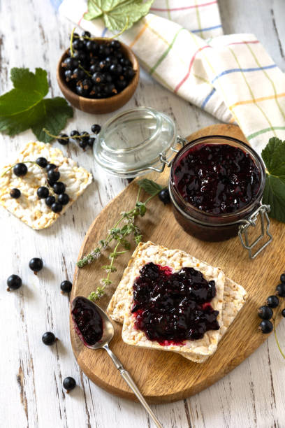 istock Blackcurrant jam in a glass jar and gluten-free crispbread on a rustic table. 1330206853