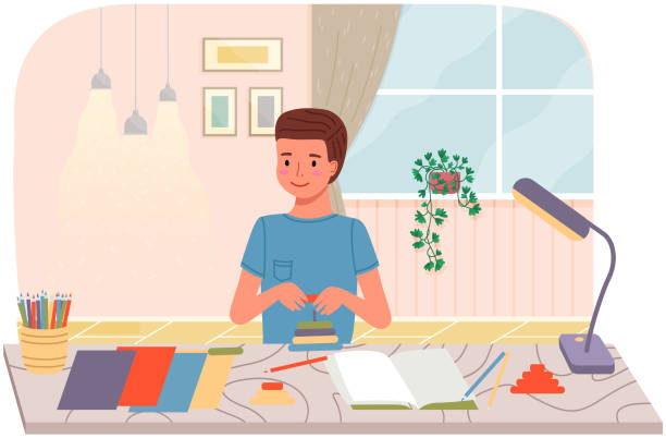 istock Guy collects toy pyramid and spends time creatively. Boy makes paper crafts, glues and cuts 1330212309