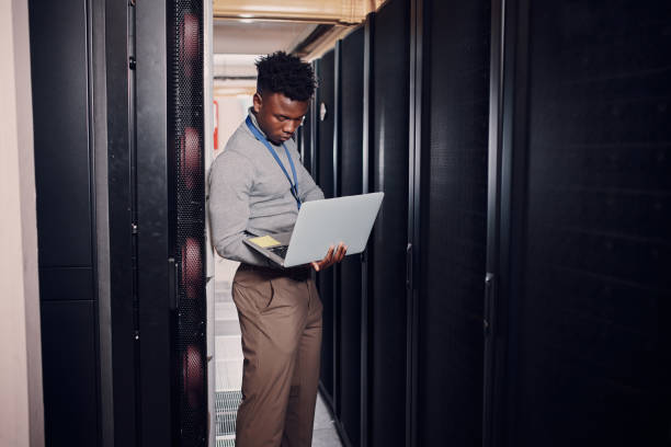 istock Shot of an attractive young man using a laptop at work in a server room 1330216551