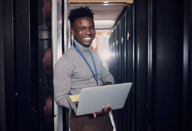 istock Portrait of a young handsome man using a laptop at work in a server room 1330216929