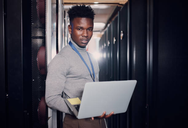 istock Portrait of a young handsome man using a laptop at work in a server room 1330216957