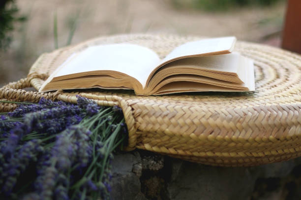 istock Straw Bag, Lavender Flowers and Open Book 1330219299