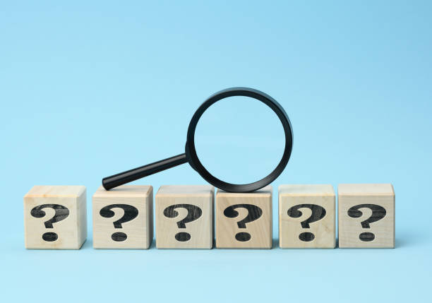 istock wooden cubes with question marks and a magnifying glass on a blue background 1330219366