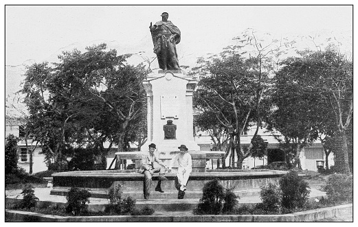 Antique black and white photograph of people from islands in the Caribbean and in the Pacific Ocean; Cuba, Hawaii, Philippines and others: Statue of Charles IV of Spain, Manila, Philippines