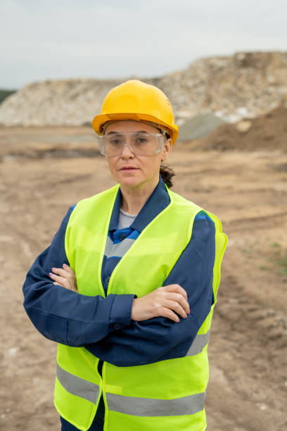 istock Female builder with crossed arms standing against quarry 1330222679
