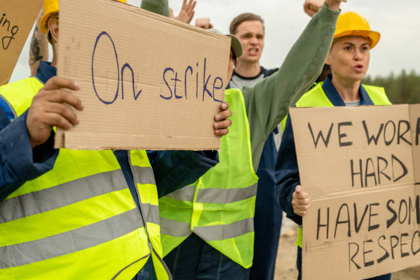 Group of angry builders or miners with placards Group of angry builders or miners with placards are on strike teamwork slogan stock pictures, royalty-free photos & images