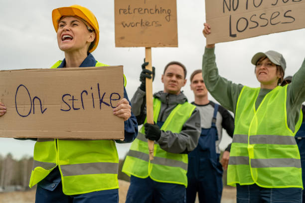 Group of employees in workwear carrying placards during strike at quarry