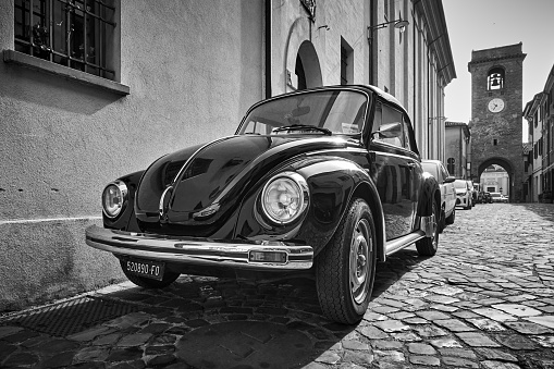 San Giovanni in Marignano, Italy - February 29, 2020:  Vintage car Volkswagen Beetle 1303 Cabriolet (1972â1980) parked in the street in old italian town. Black and white photography