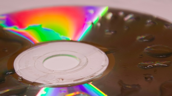 Abstract photo of wet computer cd rom with light spectrum in rainbow colors, a scientific phenomenon of light