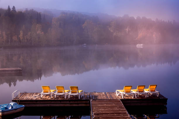 view of a boat dock the Lac-Superieur, misty morning with fog, in Laurentides, Mont-tremblant, Quebec, Canada