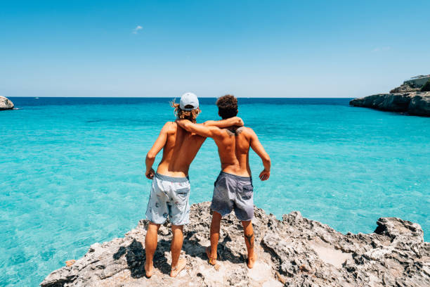 istock Two friends are standing on a cliff looking at the sea 1330224138