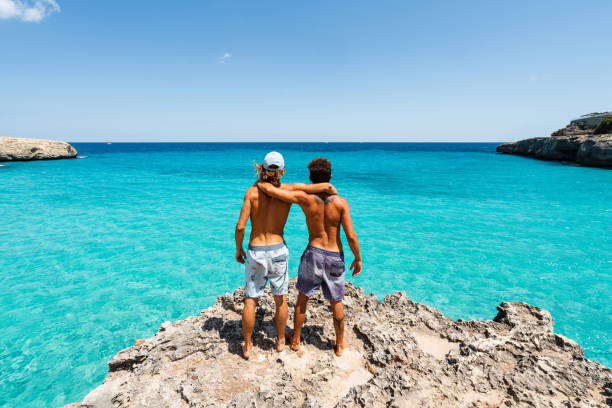 istock Two friends are standing on a cliff looking at the sea 1330224142