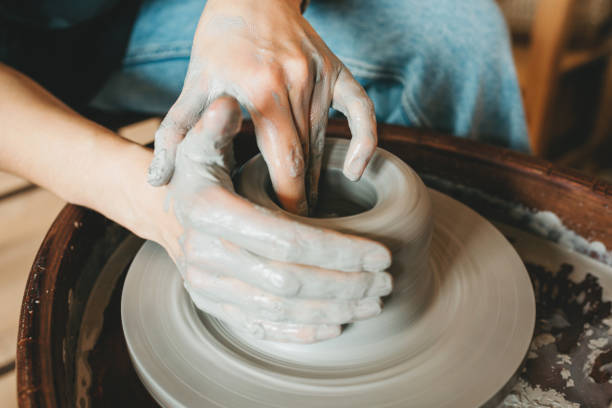 istock Female ceramics maker or potter working with pottery wheel in workshop. Creative people and handcraft pottery class concept. 1330226729