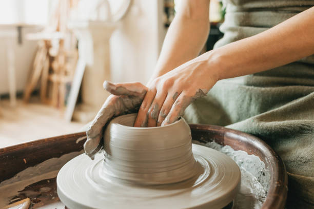 istock Female ceramics maker or potter working with pottery wheel in workshop. 1330226854