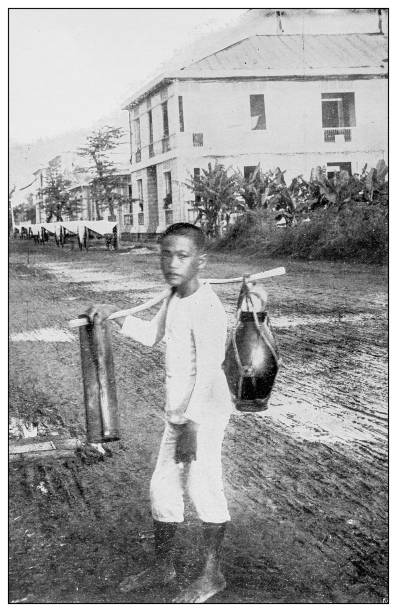 Antique black and white photograph of people from islands in the Caribbean and in the Pacific Ocean; Cuba, Hawaii, Philippines and others: Water carrier, Manila, Philippines