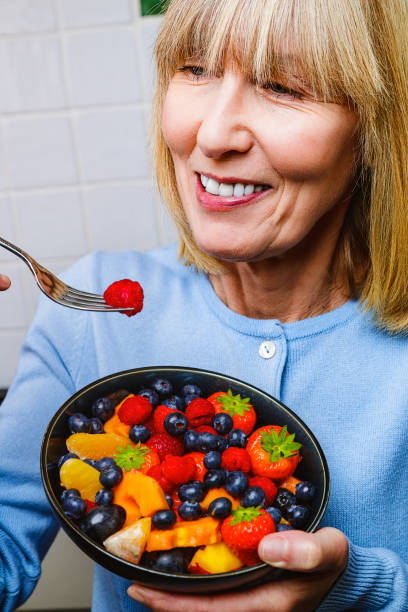 istock Attractive senior woman with fruit bowl 1330228078