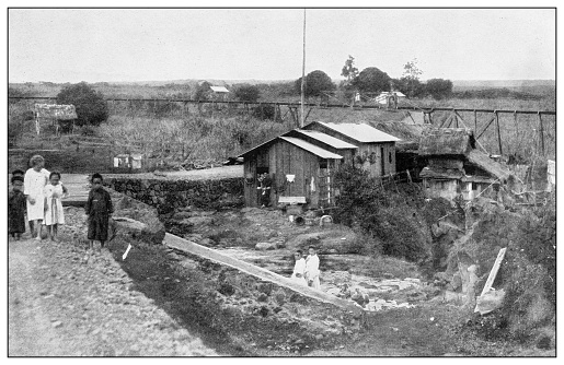 Antique black and white photograph of people from islands in the Caribbean and in the Pacific Ocean; Cuba, Hawaii, Philippines and others: Japanese laborer's huts on a sugar plantation near Hilo, Hawaii