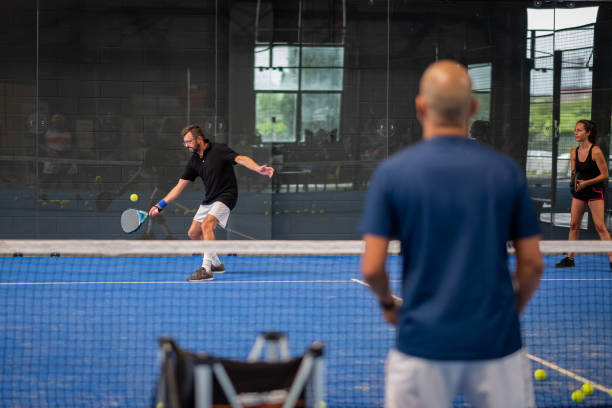 istock Monitor teaching padel class to man, his student - Trainer teaches boy how to play padel on indoor tennis court 1330229150