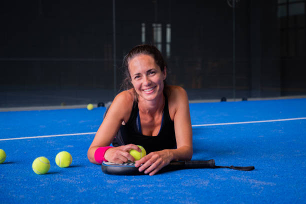 retrato de una hermosa mujer jugando a la pista de pádel bajo techo - tennis in a row team ball fotografías e imágenes de stock