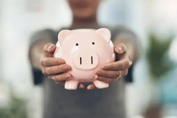 Photo of Closeup shot of an unrecognisable businesswoman holding a piggybank