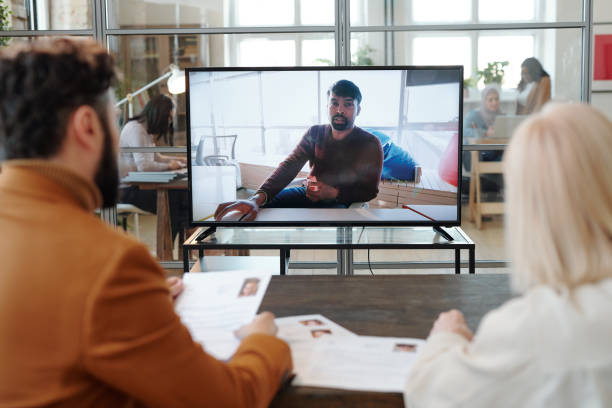 istock Two employers asking questions to man during online interview 1330232589