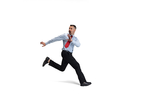 Running away from problems. One young Caucasian man, office worker, manager running isolated over white studio background. Concept of human emotions, facial expression, sales, ad. Copyspace for ad.