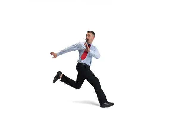 Photo of Portrait of young Caucasian man, office worker running isolated over white background. Side view