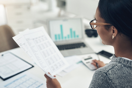 Primer plano de una empresaria irreconocible calculando finanzas en una oficina photo