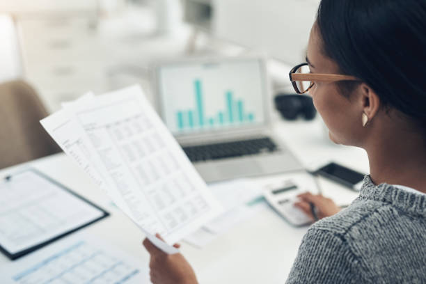 closeup shot of an unrecognisable businesswoman calculating finances in an office - data stockfoto's en -beelden