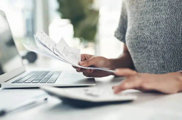 Photo of Closeup shot of an unrecognisable businesswoman calculating finances in an office