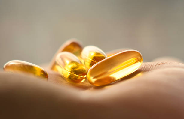 istock Yellow fish oil capsules on the arm. 1330234645