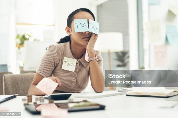 Shot Of A Young Businesswoman Covered In Sticky Notes While Working On Her Taxes In An Office Stock Photo - Download Image Now