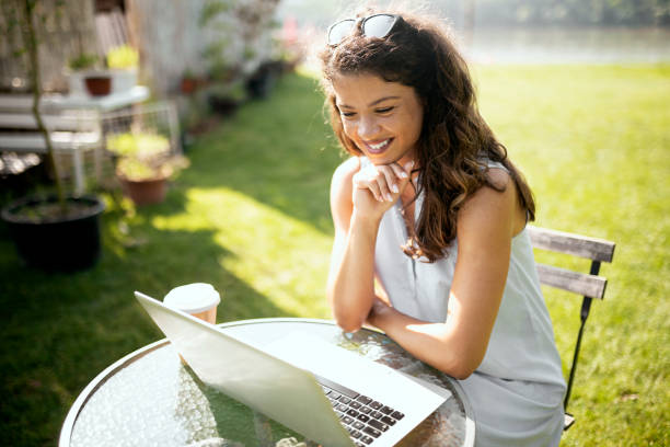 istock Young woman looking at laptop drinking coffee 1330234743