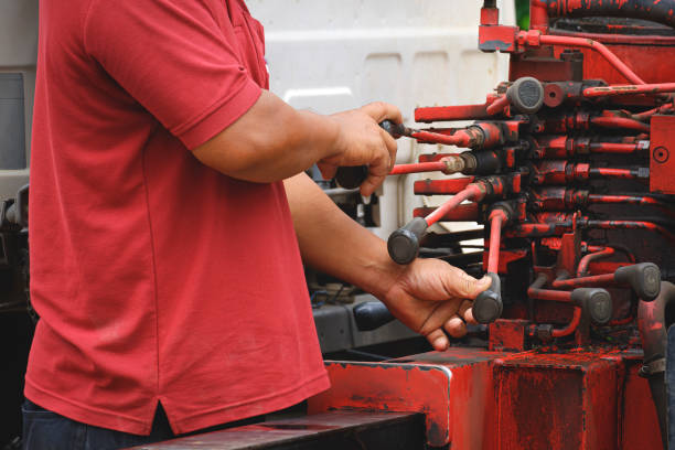 istock Technician's hand is controlling operate hydraulic levers of red crane truck 1330237915