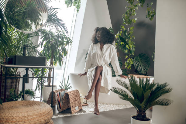 istock Dark-skinned woman in robe barefoot at spa 1330238065