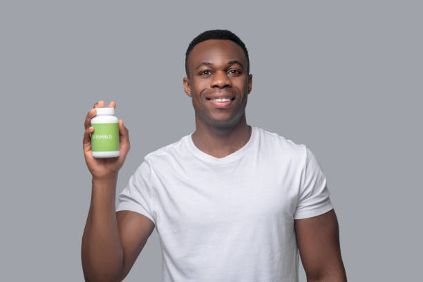 istock A dark-skinned man in a white thsirt choosing vitamins 1330240329